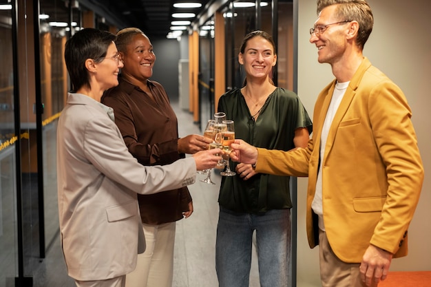 Medium shot people clinking glasses