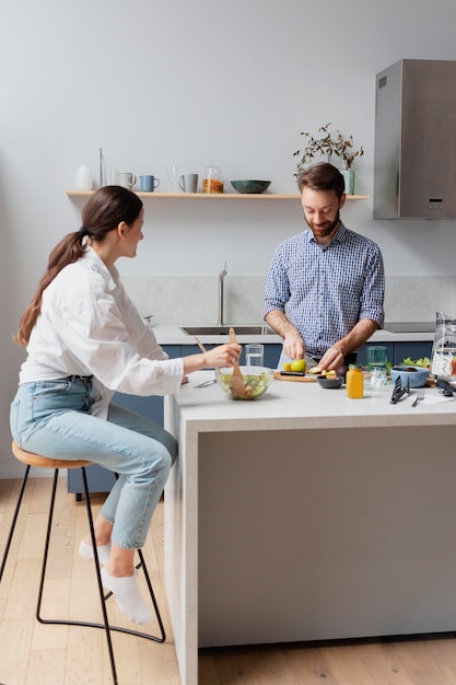 Foto persone di livello medio che preparano il cibo a casa