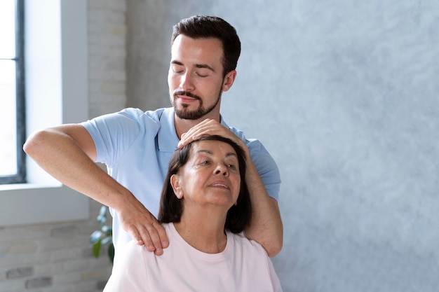 Photo medium shot physiotherapist helping woman