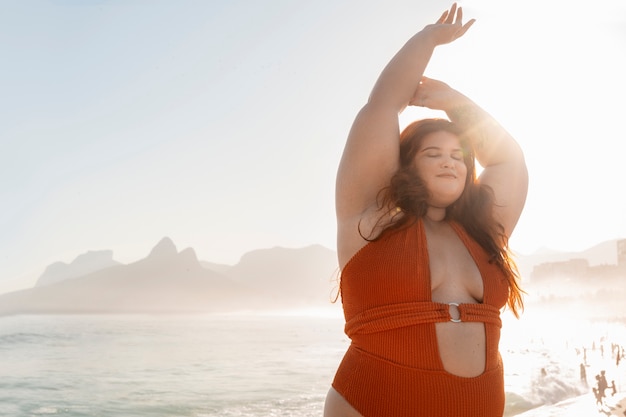 Foto una donna di taglia media che posa in riva al mare