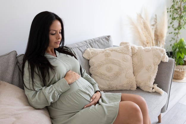 Photo medium shot pregnant woman on couch