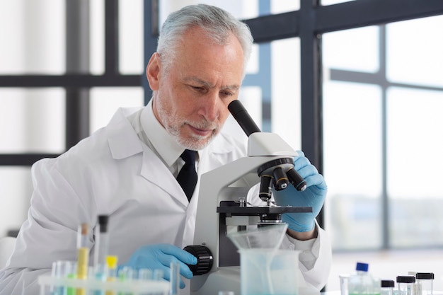 Medium shot scientist looking through microscope