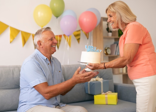 Foto coppia senior di tiro medio che festeggia il compleanno