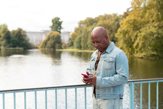 Medium shot senior man holding phone