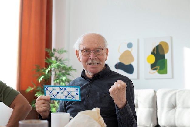 Foto uomo anziano a tiro medio che gioca a bingo