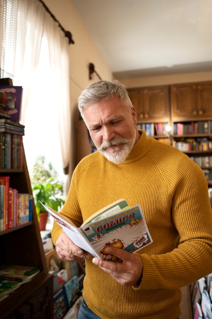 Photo medium shot senior man reading comics