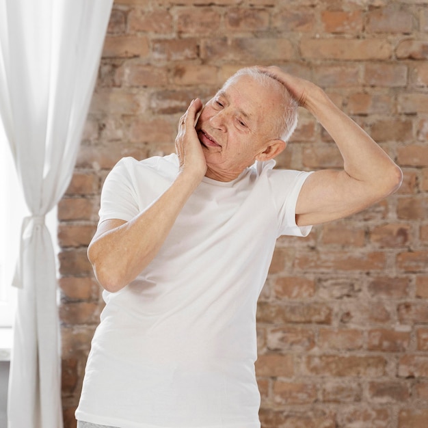 Medium shot senior man stretching indoors