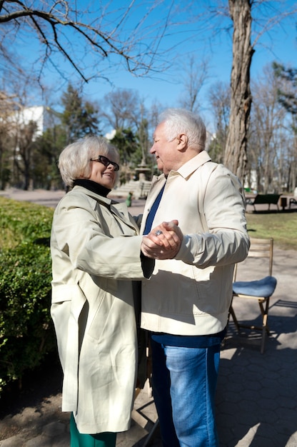 Medium shot senior people dancing in park