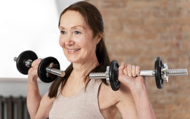 Photo medium shot senior woman with dumbbells