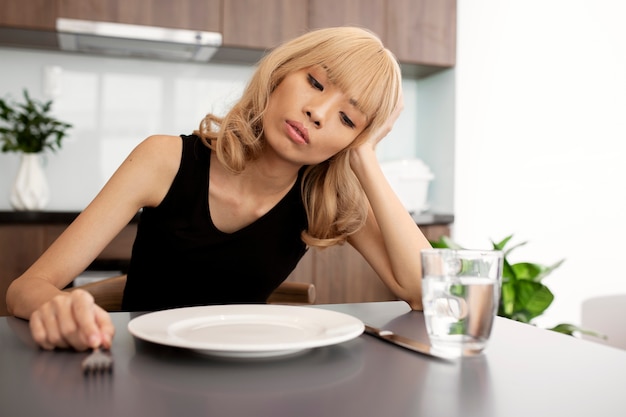 Medium shot sick woman with empty plate