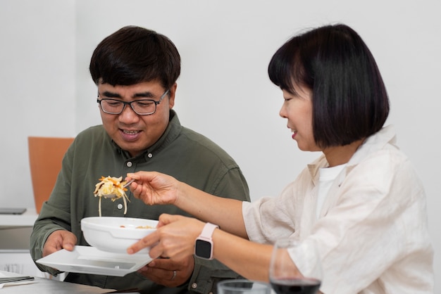 Medium shot smiley couple eating