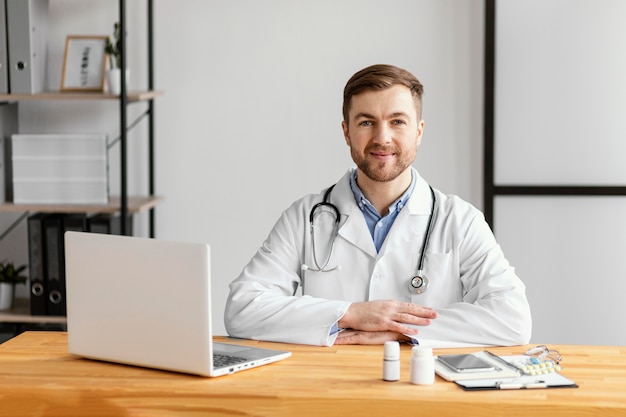 Foto medico di smiley del colpo medio alla scrivania