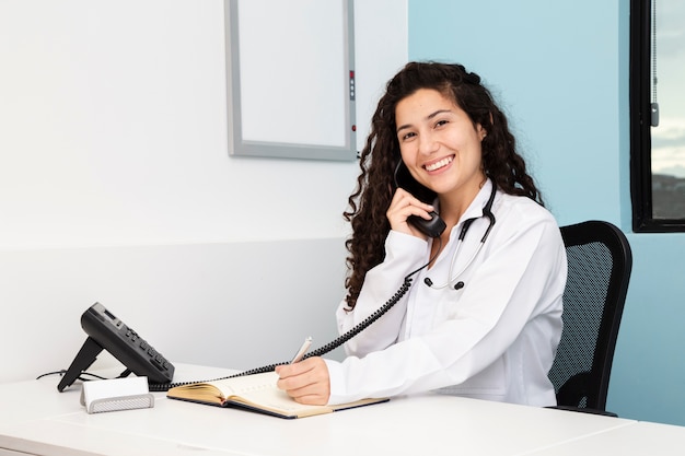 Medico di smiley del colpo medio sul telefono