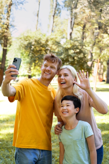 Medium shot smiley family taking selfie