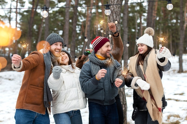 Photo medium shot smiley friends holding fireworks