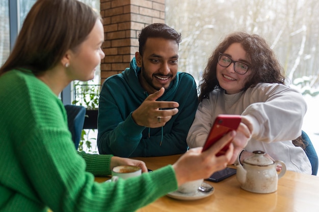 Photo medium shot smiley friends with smartphone