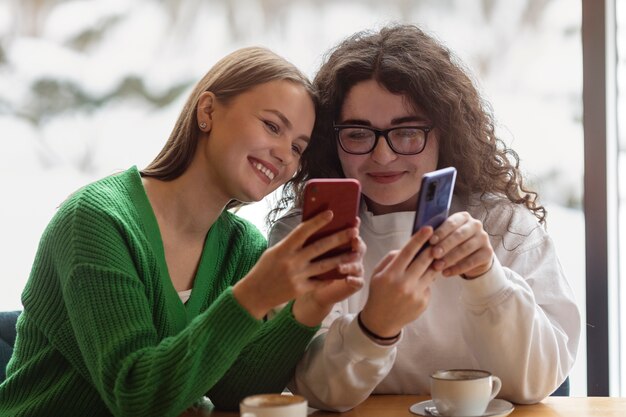 Photo medium shot smiley friends with smartphone