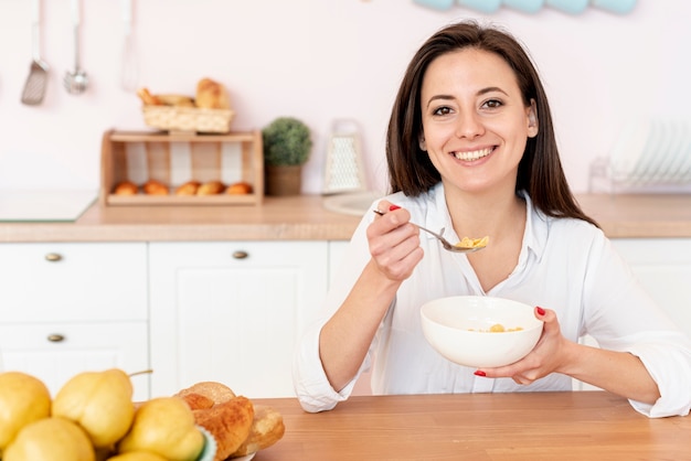 Medium shot smiley girl eating cereals