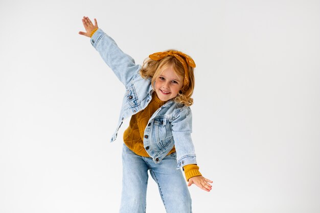 Medium shot smiley girl posing in studio