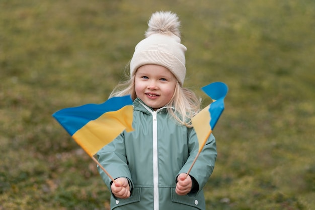 Photo medium shot smiley kid holding krainian flags