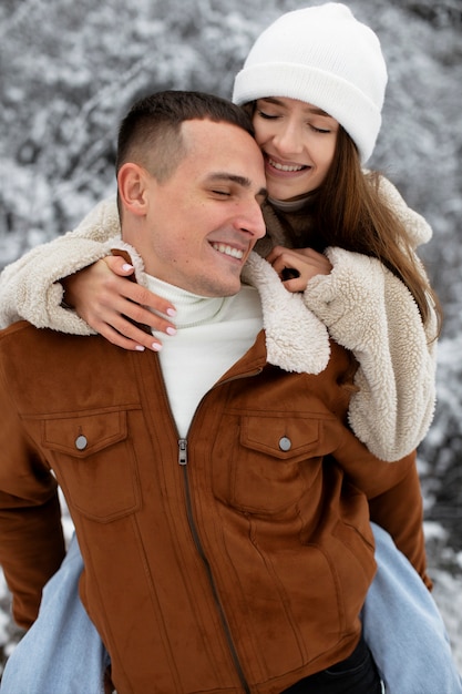 Foto uomo sorridente con tiro medio che porta donna