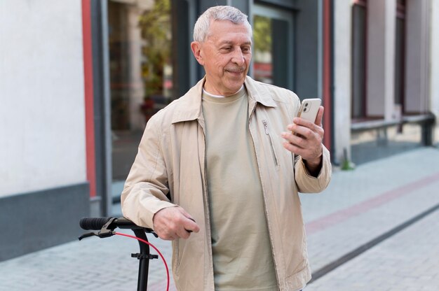 Uomo sorridente con colpo medio che tiene il telefono