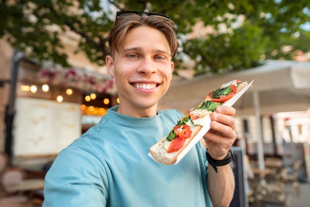 食べ物でポーズをとるミディアムショットのスマイリー男