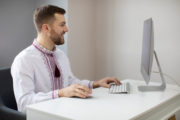 Foto uomo sorridente del colpo medio che indossa una camicia ricamata