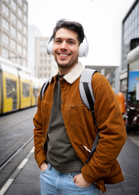 Foto uomo sorridente con tiro medio con le cuffie