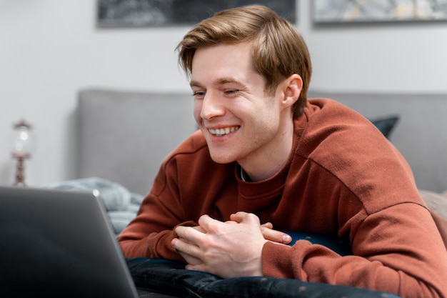 Foto uomo sorridente del colpo medio con il computer portatile