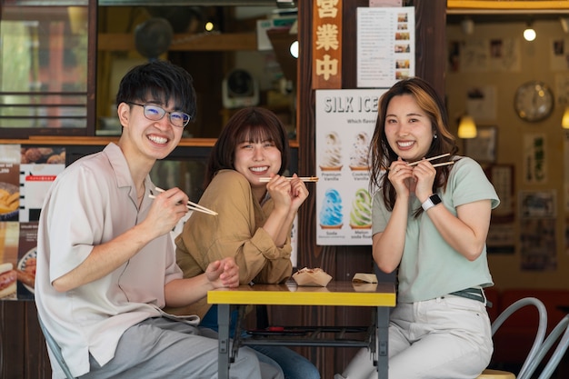 Foto persone sorridenti a colpo medio che mangiano insieme