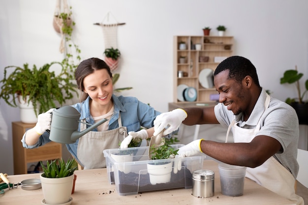 Medium shot smiley people transplanting plants