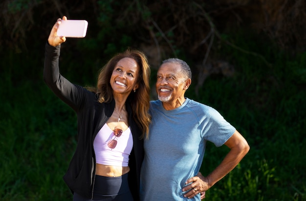 Foto persone anziane sorridenti del colpo medio che prendono selfie