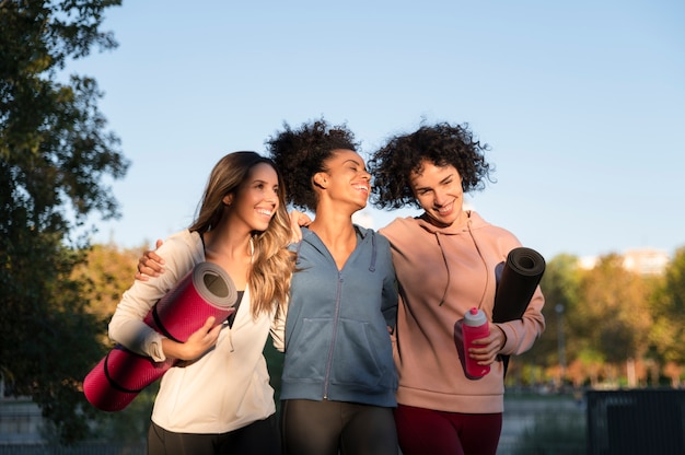 Foto donne sportive sorridenti a colpo medio all'aperto