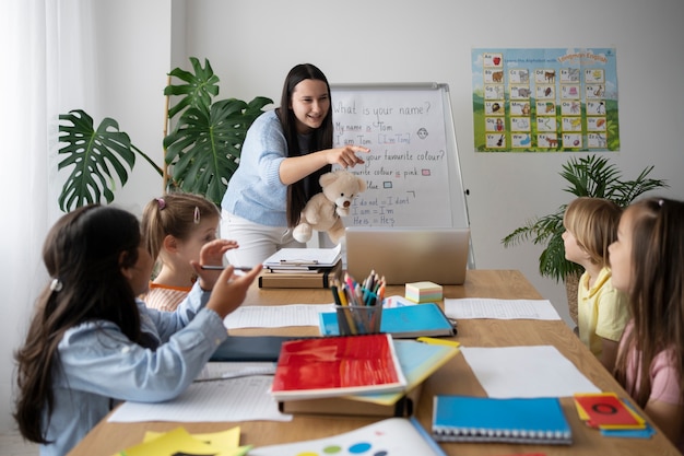 Photo medium shot smiley teacher holding teddy bear