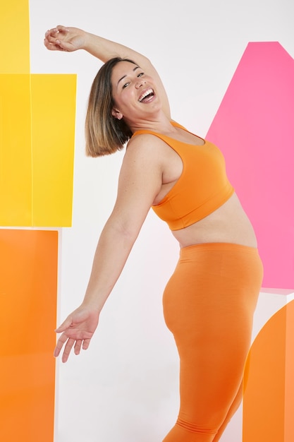 Foto medium shot smiley vrouw met oranje sportieve outfit