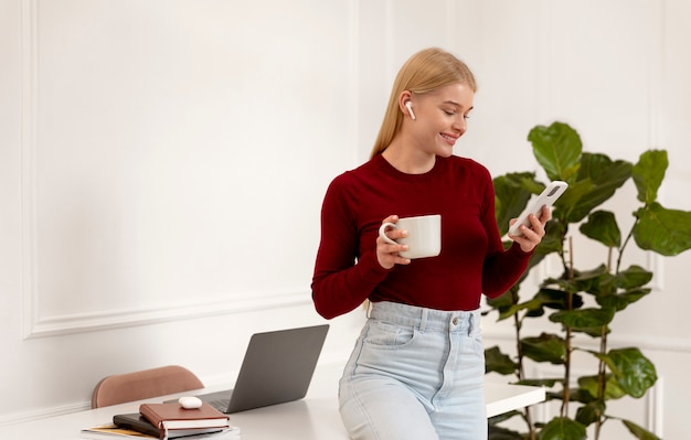 Medium shot smiley woman holding device