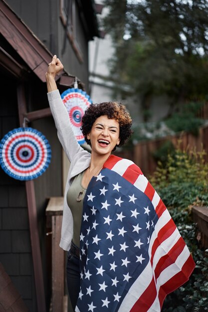 Medium shot smiley woman holding flag outdoors