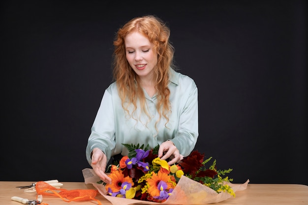 Foto donna sorridente di colpo medio che tiene i fiori