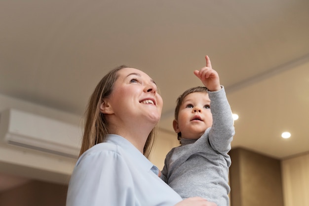 Medium shot smiley woman holding kid