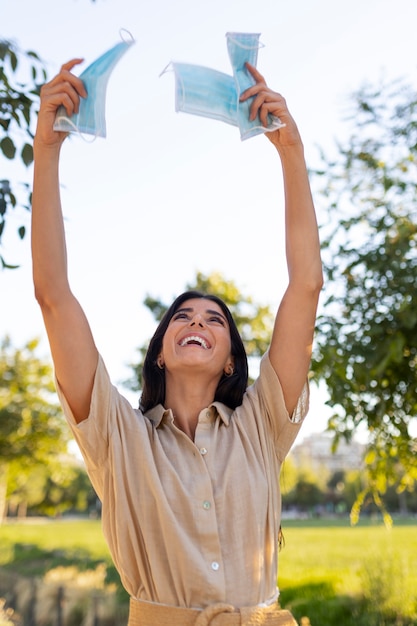 Medium shot smiley woman holding masks