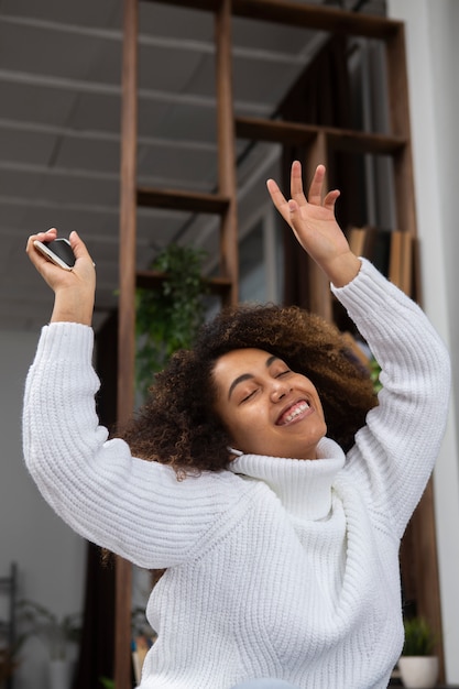 Medium shot smiley woman holding phone