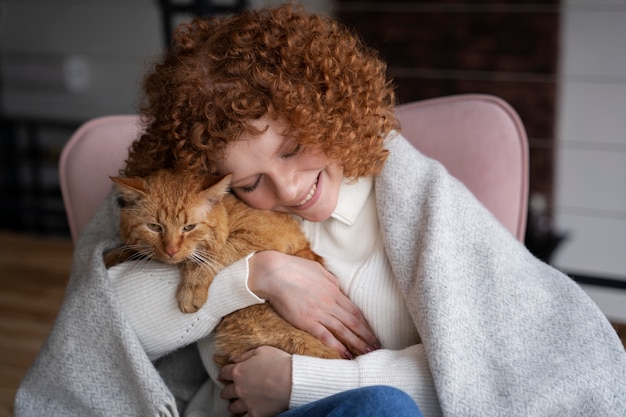 Foto donna sorridente del colpo medio che abbraccia gatto