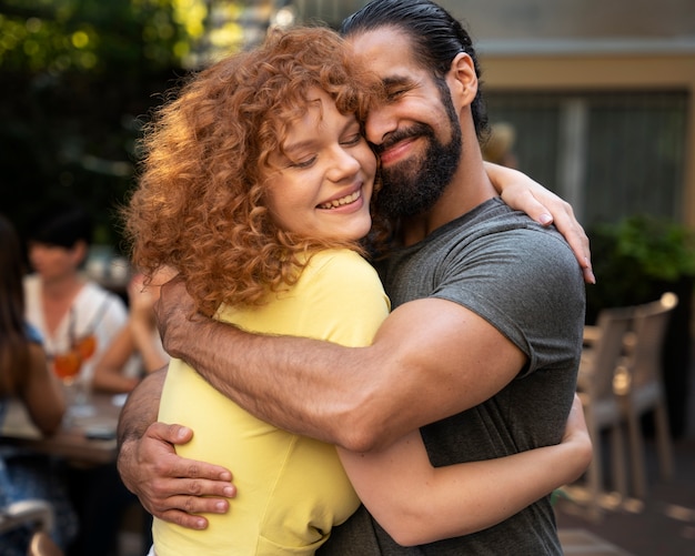 Medium shot smiley woman and man hugging