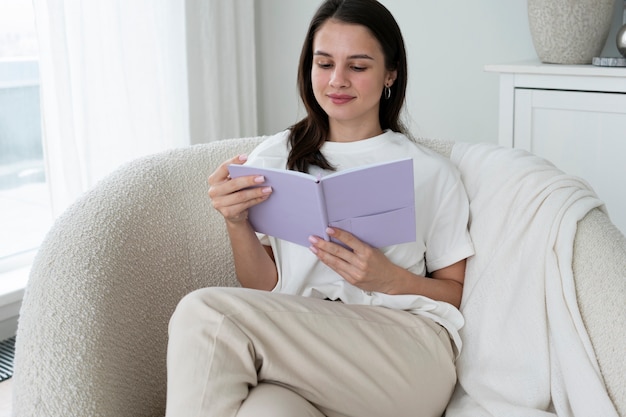 Photo medium shot smiley woman reading at home