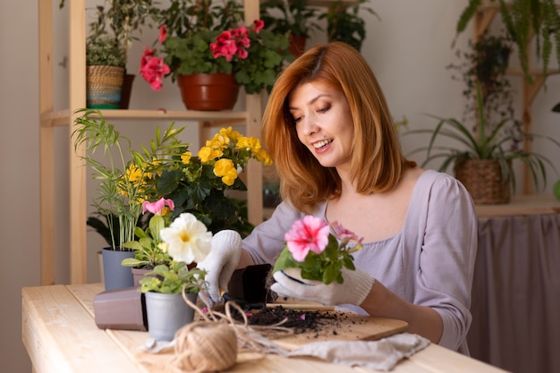 植物の世話をするミディアムショットの笑顔の女性