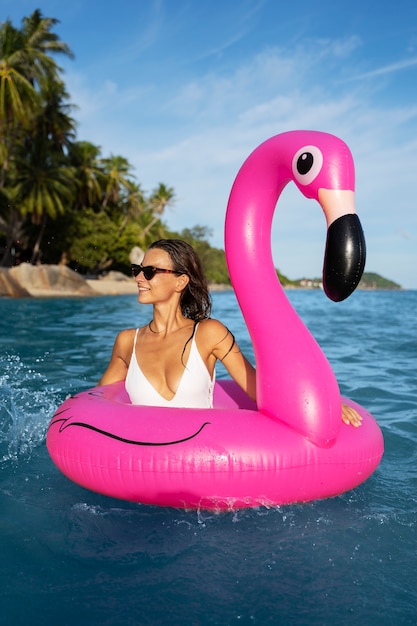 Medium shot smiley woman with flamingo floater