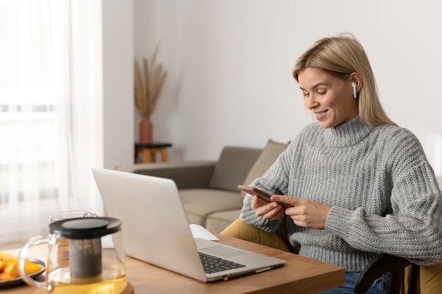 Medium shot smiley woman with laptop