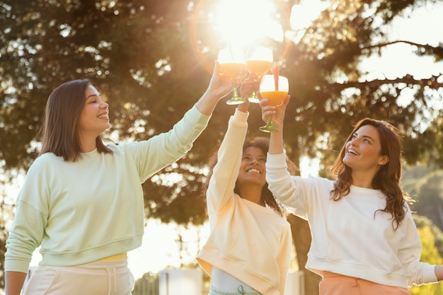 Foto donne di smiley colpo medio che tintinnano le bevande