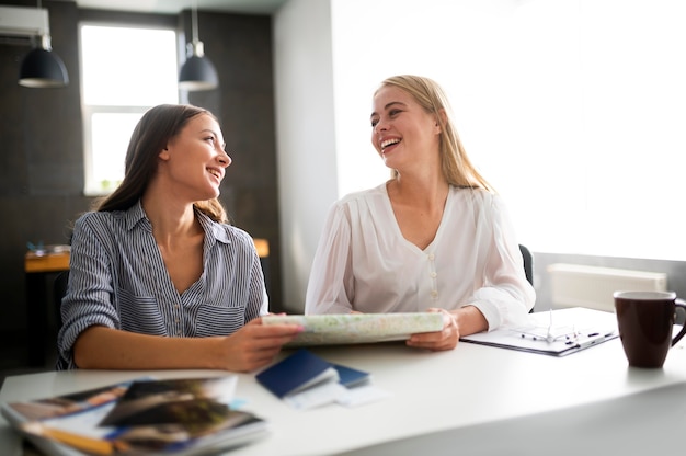 Foto donne sorridenti a colpo medio che tengono mappa